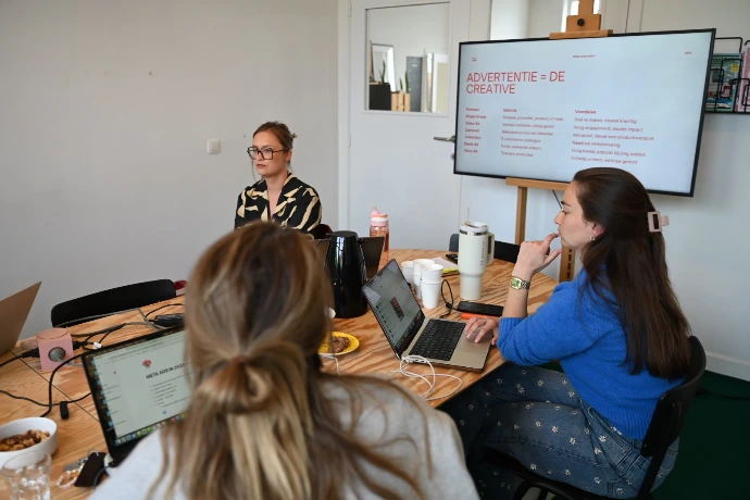 Laura De Smet tijdens een sessie met een marketingteam rond de tafel